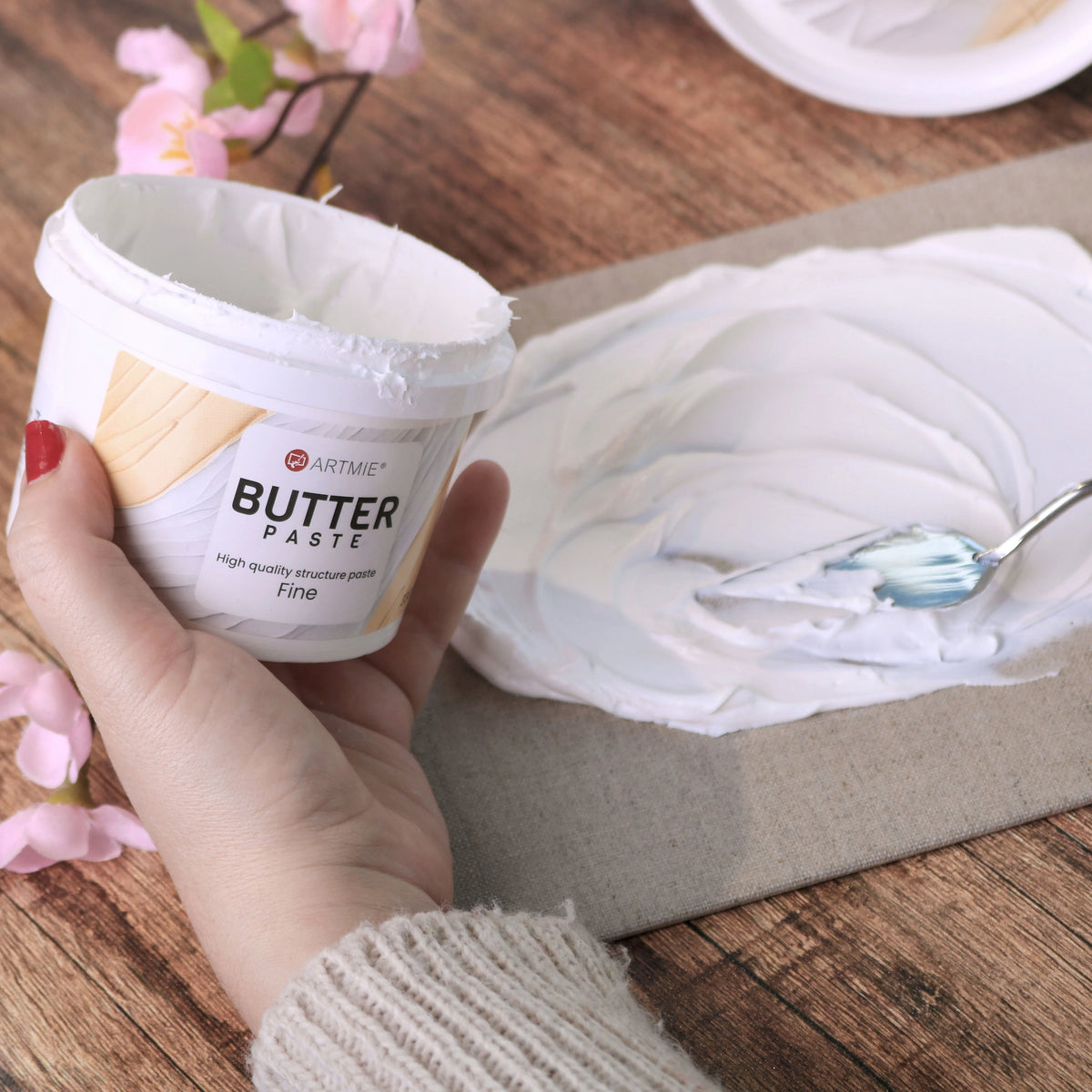 Nyitott tégely és vászonra felvitt ARTMIE Butter Fine paszta réteg festőkéssel